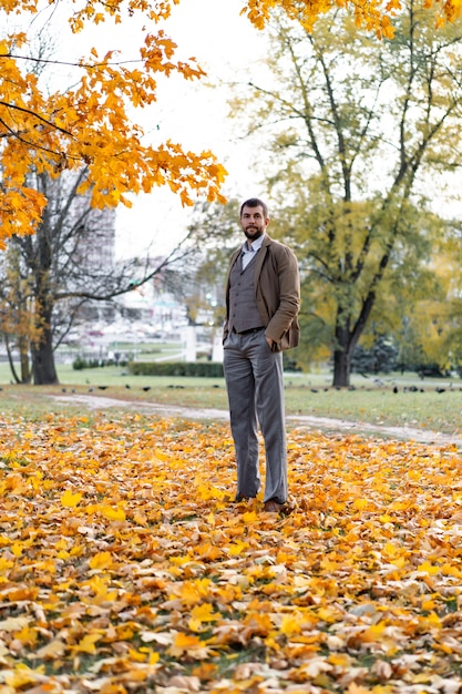 mężczyznę idącego w parku jesienią