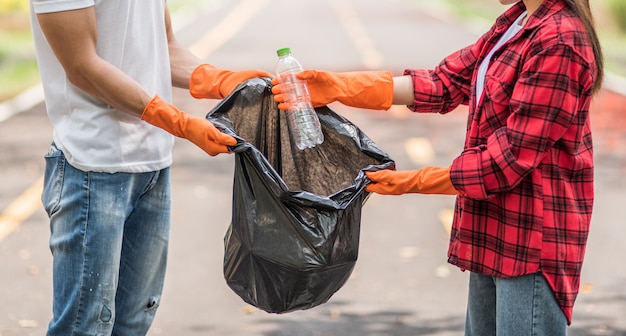 Bezpłatne zdjęcie mężczyźni i kobiety pomagają sobie nawzajem w zbieraniu śmieci.