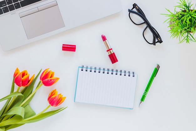 Miejsce pracy z notatnikiem i laptopem z tulipanem i pomadą