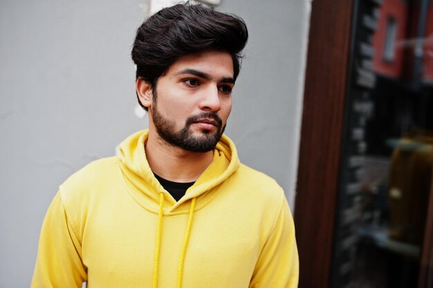 Miejski młody indyjski hipster w modnej żółtej bluzie Fajny południowoazjatycki facet nosi bluzę z kapturem