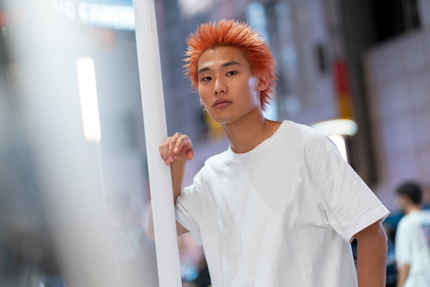 Miejski portret młodego mężczyzny z pomarańczowymi włosami