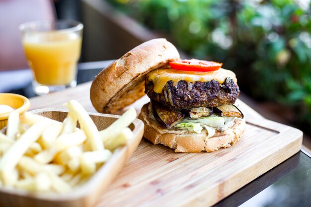 Mięsny burger z sałatką, bakłażanem, serem i pomidorem z boku