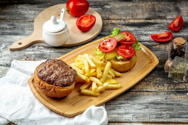 Bezpłatne zdjęcie mięso burger sałata pomidorowa frytki widok z boku