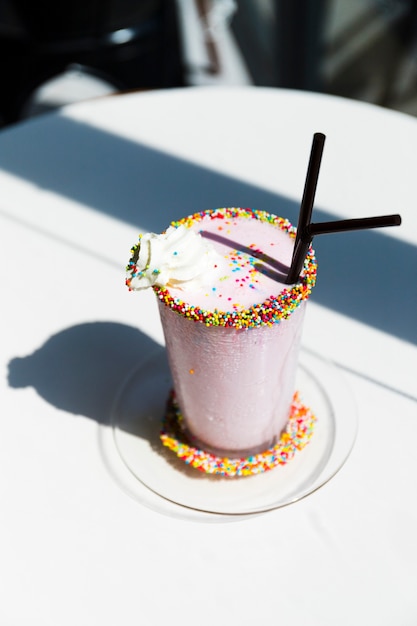 Milkshake truskawkowy z bitą śmietaną i posypać