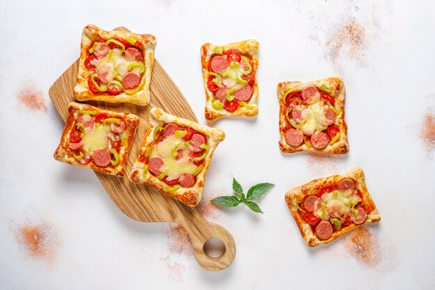 Bezpłatne zdjęcie mini pizze z ciasta francuskiego z kiełbasami.