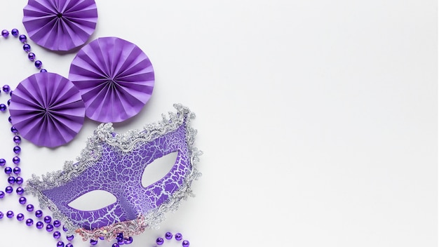 Bezpłatne zdjęcie minimalistyczna maska karnawałowa i fioletowe papierowe dekoracje