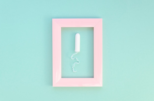 Minimalistyczny tampon na niebieskim tle i różowej ramie