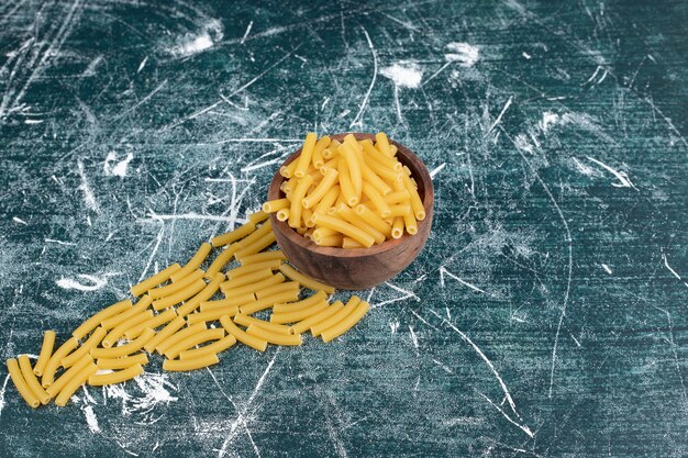 Miska makaronu penne na niebieskim tle. Wysokiej jakości zdjęcie