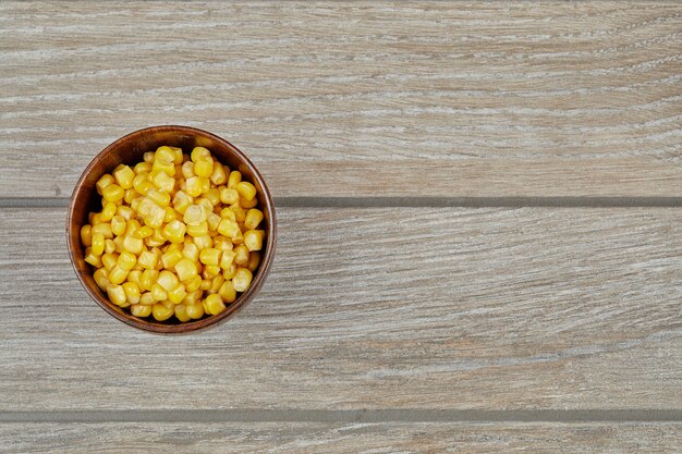 Bezpłatne zdjęcie miskę gotowanej kukurydzy na drewnianym stole.
