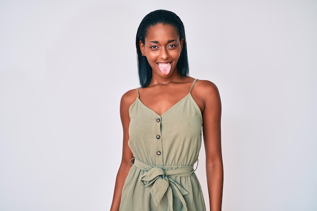 Bezpłatne zdjęcie młoda afroamerykanka ubrana w zwykłe ubrania z wystającym językiem zadowolona z zabawnego wyrazu twarzy. koncepcja emocji.