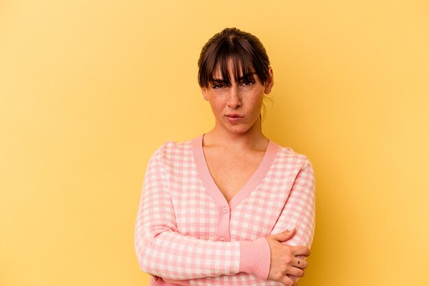 Młoda argentyńska kobieta na białym tle na żółtym tle niezadowolony patrząc w aparacie z sarkastycznym wyrazem.