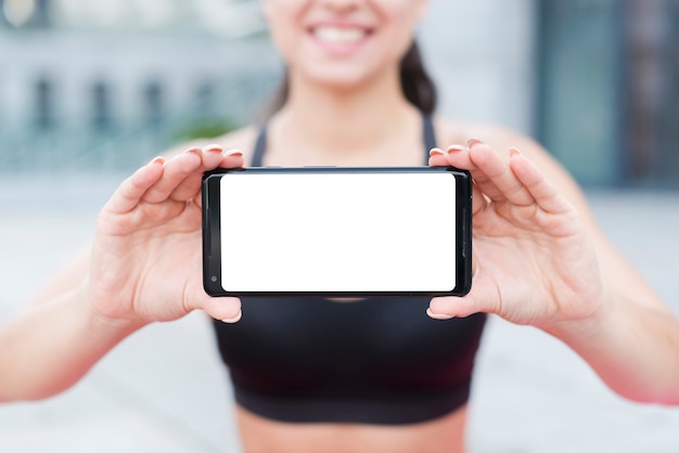 Młoda atlety kobieta z smartphone