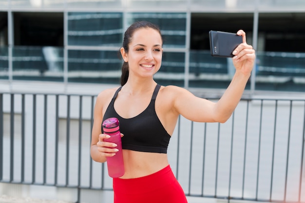 Młoda atlety kobieta z smartphone