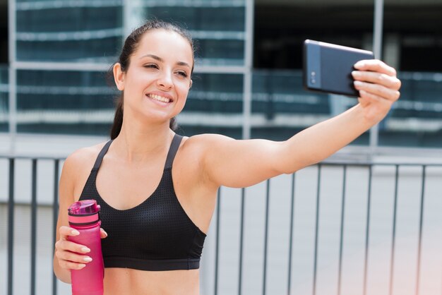 Młoda atlety kobieta z smartphone