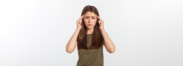 Młoda atrakcyjna kobieta cierpiąca na chorobę lub ból głowy, trzymająca głowę na białym tle