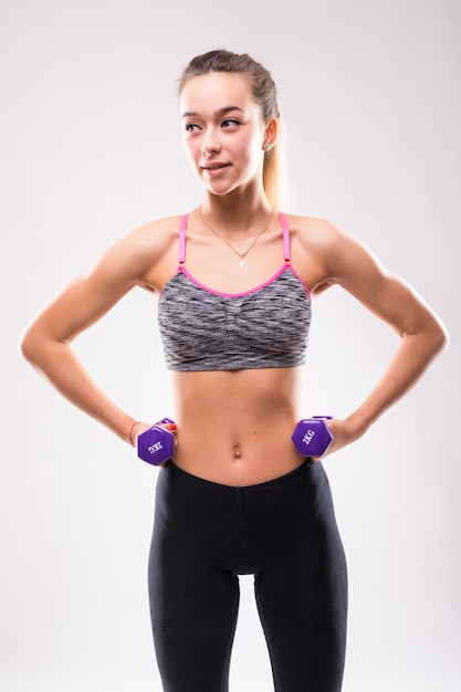 Młoda atrakcyjna kobieta dziewczyna fitness zrobić różne ćwiczenia aerobiku z hantlami na białym tle