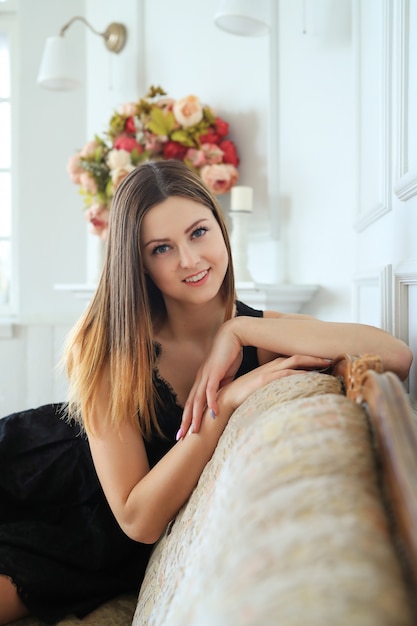 Bezpłatne zdjęcie młoda atrakcyjna kobieta pozuje w kanapie