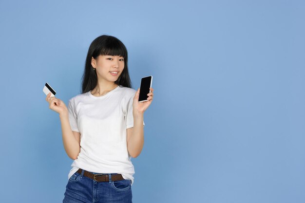 Młoda azjatycka kobieta z kartą kredytową i smartfonem