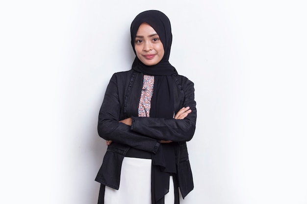 Młoda azjatycka muzułmańska biznesowa kobieta w uśmiechu na głowie z rękoma skrzyżowanymi na białym tle