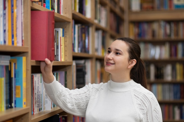 Bezpłatne zdjęcie młoda bibliotekarka organizująca książki