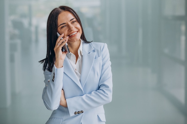 Młoda biznesowa kobieta korzystająca z telefonu komórkowego