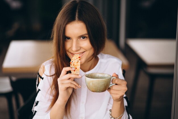 Młoda biznesowa kobieta pije kawę w kawiarni