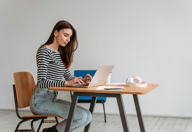 Młoda biznesowa kobieta pracuje na laptopie