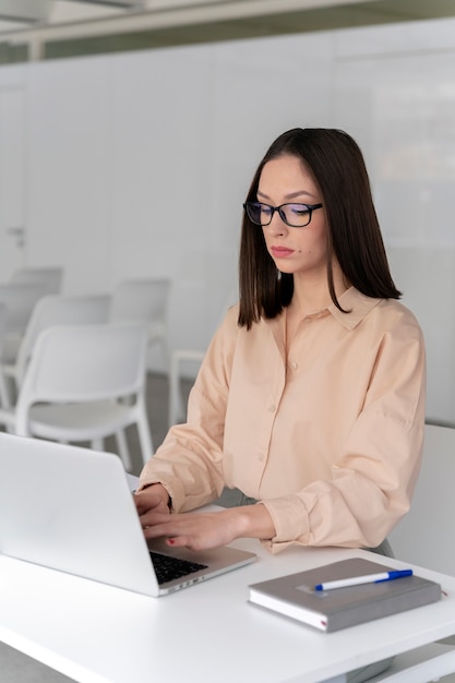 Młoda biznesowa kobieta pracuje przy biurku z laptopem