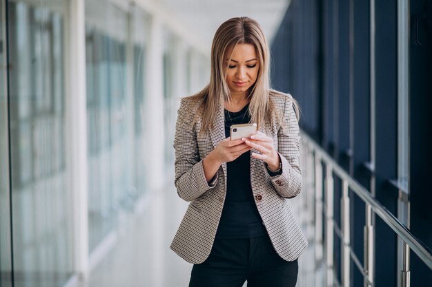 Młoda biznesowa kobieta używa telefon w terminal