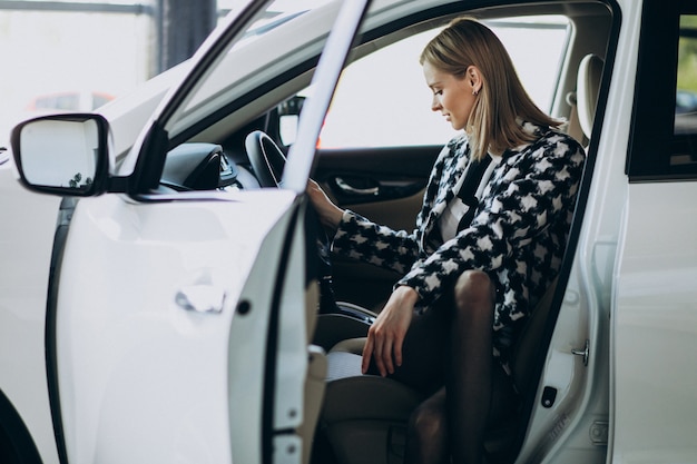 Bezpłatne zdjęcie młoda biznesowa kobieta wybiera samochód