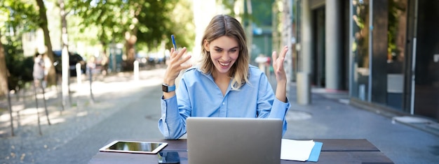 Bezpłatne zdjęcie młoda bizneswoman bierze udział w wideokonferencji online, zapisując, pracując i robiąc w niej notatki