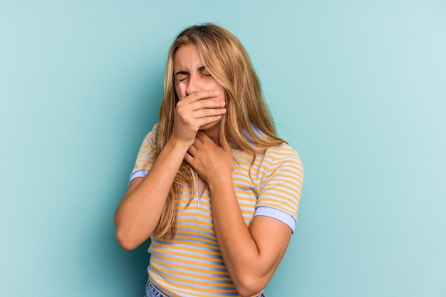 Młoda blond kobieta kaukaski na białym tle na niebieskim tle cierpi na ból gardła z powodu wirusa lub infekcji.