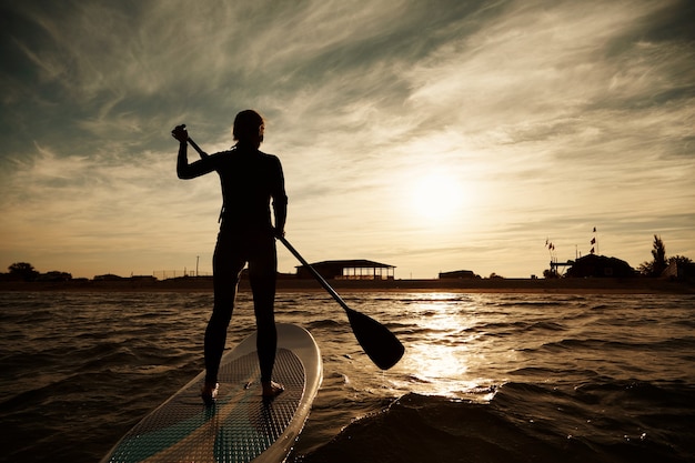 Bezpłatne zdjęcie młoda blond kobieta na paddleboard na morzu