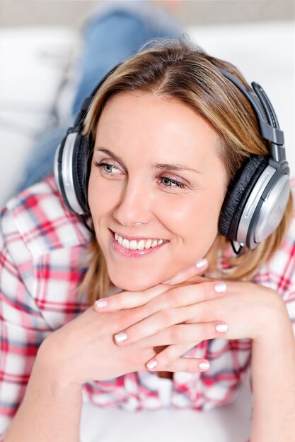 Młoda blond kobieta słuchania muzyki w słuchawkach