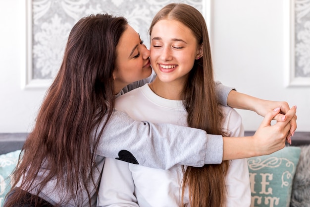 Bezpłatne zdjęcie młoda brunetka całuje jej dziewczynę