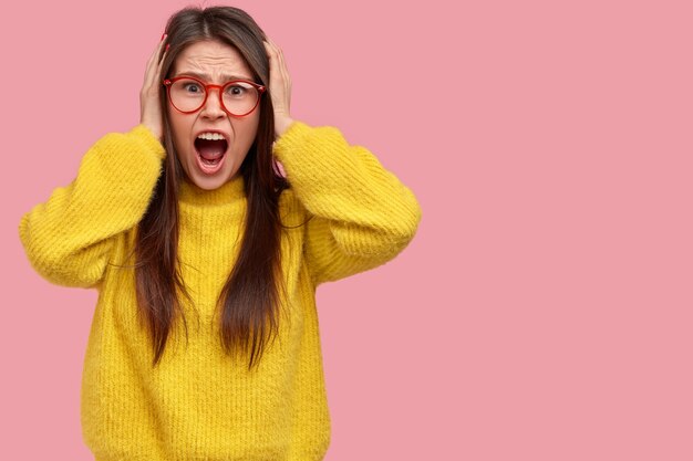 Młoda brunetka kobieta w żółtym swetrze