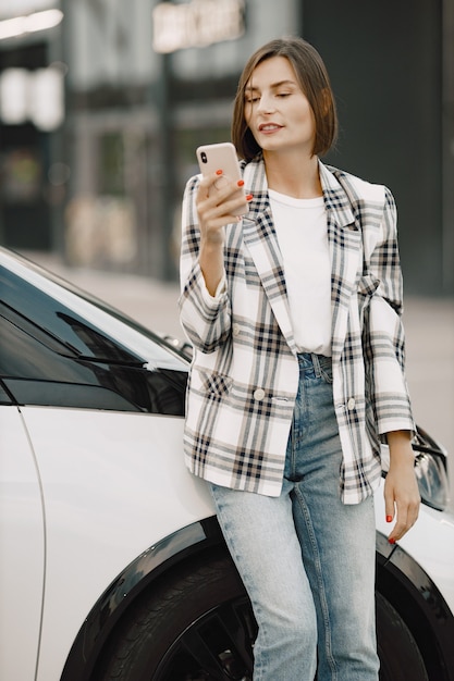 Młoda Brunetka Rozmawia Przez Telefon Komórkowy, Siedząc W Bagażniku Samochodu