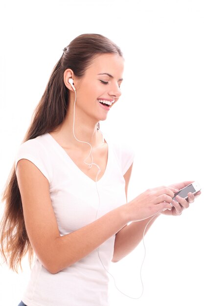 Młoda brunetki kobieta z słuchawkami i smartphone