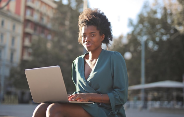 młoda czarna kobieta na ulicy z komputerem