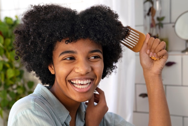 Młoda czarna osoba dbająca o włosy afro