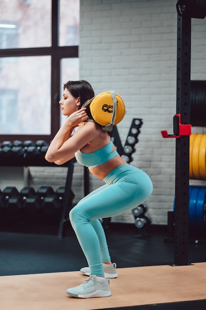 Młoda dorosła kobieta robi sile ćwiczy w gym