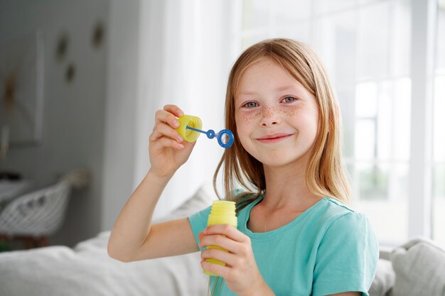 Młoda dziewczyna bawi się bańkami mydlanymi