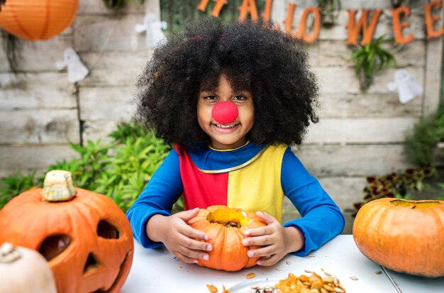 Młoda dziewczyna cieszy się rzeźbić jej Halloweenowej bani