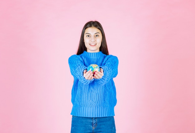 Młoda Dziewczyna Model Oferuje Małą Kulę Ziemi.