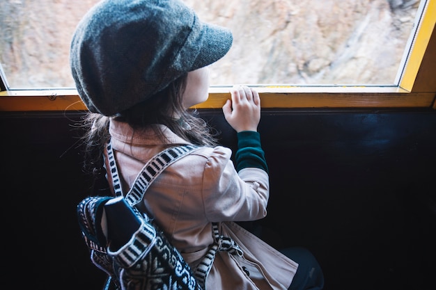 Młoda dziewczyna patrzeje taborowego okno