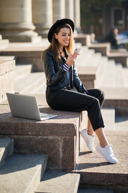 Młoda dziewczyna student businesswoman pracuje z laptopem swojej marki w centrum miasta