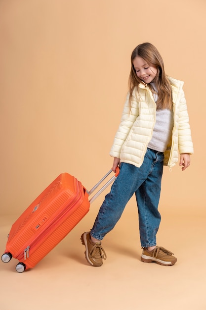 Bezpłatne zdjęcie młoda dziewczyna trzyma bagaż gotowy do podróży wakacje
