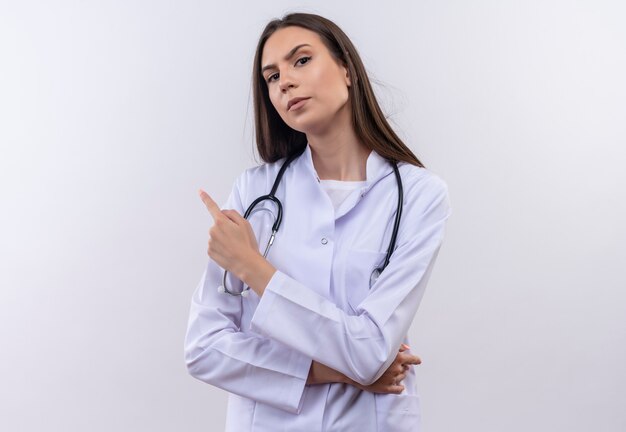 młoda dziewczyna ubrana w stetoskop medycznej sukni wskazuje bok na pojedyncze białej ścianie