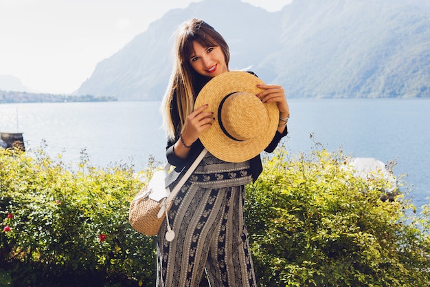 Młoda elegancka kobieta w słomkowym kapeluszu w jeziorze Como