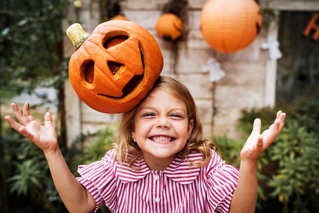 Bezpłatne zdjęcie młoda figlarnie dziewczyna z jej halloweenowym dźwigarka lampionem